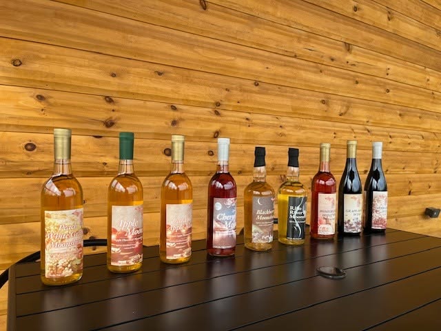 The moonshine and wine lineup on the pine wall