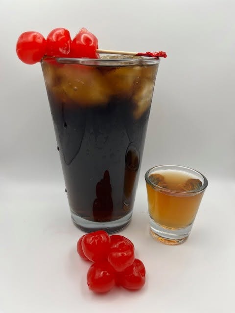Cherry moonshine cocktail with a shot on the side