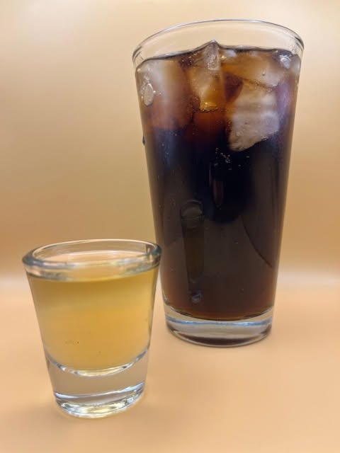 Moonshine shot beside a tall mixed drink