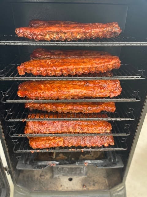 Racks of ribs smoking in the smoker