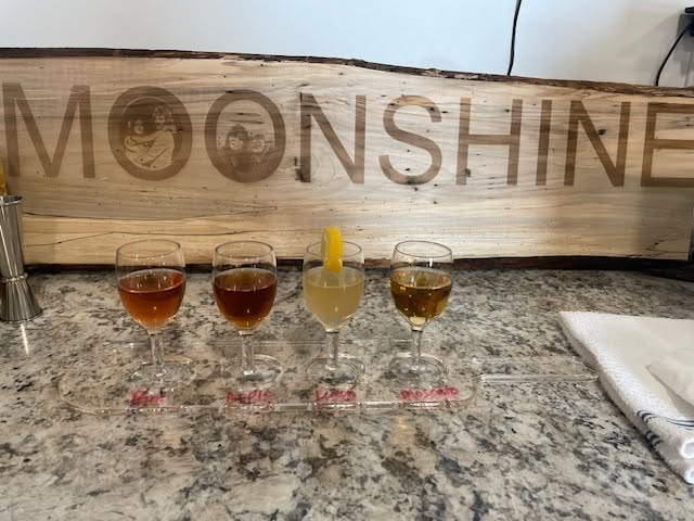 A moonshine tasting flight under the MOONSHINE sign